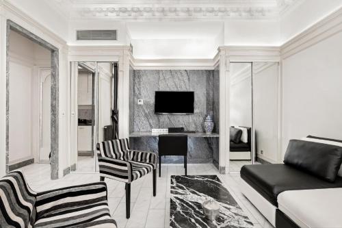 un salon avec un canapé et une télévision dans l'établissement The Paris Guest, à Paris