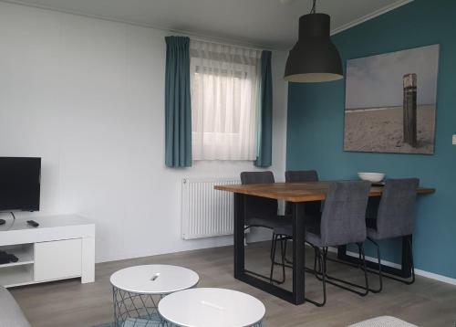 a living room with a dining room table and chairs at Klein Ramdal in Putten