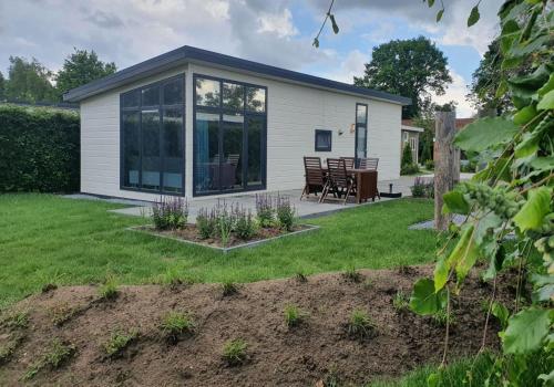 a cottage with a garden and a patio at Klein Ramdal in Putten