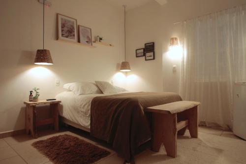 a bedroom with a bed and a table and lights at Hospedagem Fazenda Nova América in Brotas
