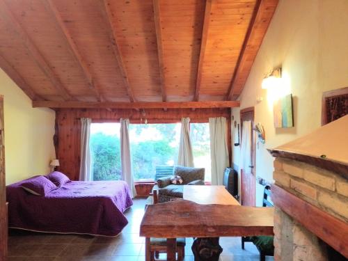 um quarto com uma cama e uma mesa num quarto em Cabaña en el bosque em San Carlos de Bariloche