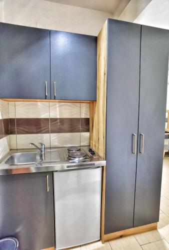 a kitchen with stainless steel cabinets and a sink at MD APARTMENTS in Ulcinj