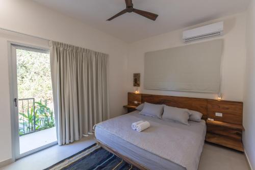 um quarto com uma cama e uma grande janela em Villa Venus em Santa Teresa
