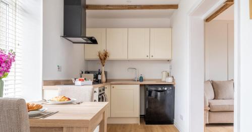 a kitchen with white cabinets and a wooden table at Central Kendal Retreat - Work or Holiday friendly in Kendal