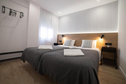 a bedroom with two beds with towels on them at Apartamento Logroño Plaza Ayuntamiento in Logroño