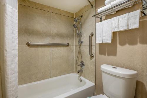 a bathroom with a tub and a toilet and a shower at Super 8 by Wyndham McDonough GA in McDonough