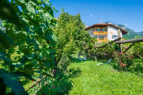 a house in the middle of a garden at Sandhof Ferienwohnungen in Termeno