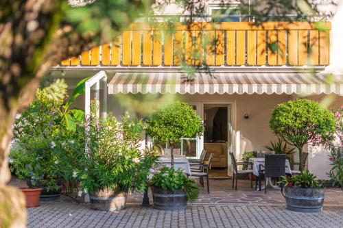 a house with potted plants and a balcony at Sandhof Ferienwohnungen in Termeno