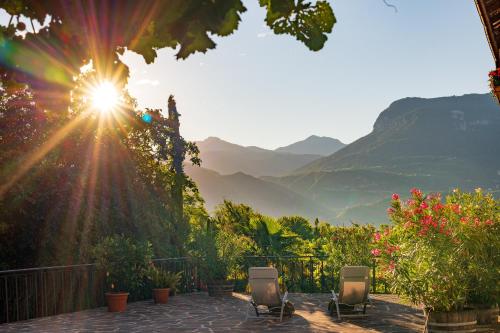a view of the mountains from a patio with chairs at Sandhof Ferienwohnungen in Termeno