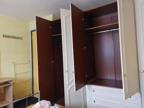 a bedroom with a closet with brown and white cabinets at Basildon House in Basildon