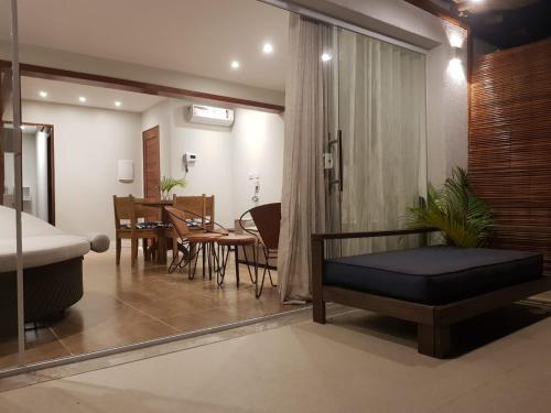 un soggiorno con un letto e una sala da pranzo di Pouso do Sol - Apartamento com Vista Panorâmica em Morro a Morro de São Paulo