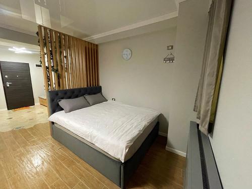 a bedroom with a bed and a clock on the wall at Azimuth Resort in Mamaia Nord