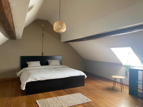 a bedroom with a large bed and a window at Huis Louis in Kortessem