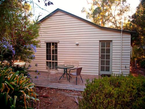 a house with a patio and a patio chair at Noonameena Cottage in Halls Gap