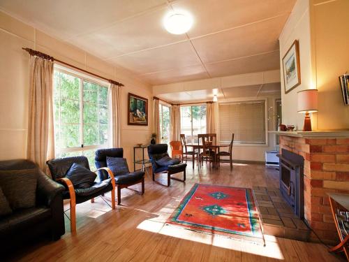 a living room filled with furniture and a fire place at Noonameena Cottage in Halls Gap