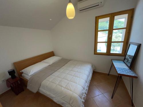a bedroom with a bed and a window at Beach house Evita in Prožura