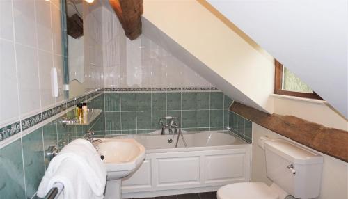 Sheep Dip Cottage - 5* Cyfie Farm, with log burner and private hot tub في Llanfyllin: حمام مع حوض وحوض استحمام ومرحاض