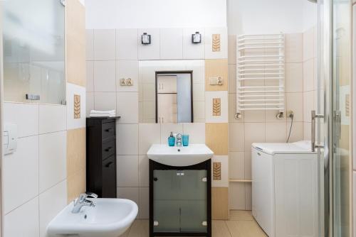 een badkamer met 2 wastafels en een spiegel bij Next to the Wisła river in Krakau