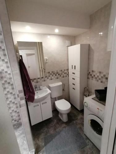 a bathroom with a white toilet and a sink at VEMIUR in Čačak