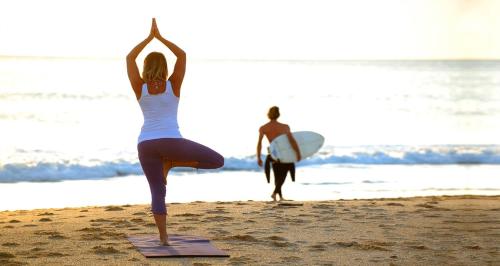 Twee vrouwen doen yoga op het strand. bij Vibe Surf Morocco in Agadir