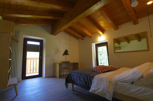ein Schlafzimmer mit einem Bett in einem Zimmer mit Holzdecke in der Unterkunft Péstrofa in San Pietro al Natisone