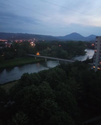 a bridge over a river in a city at night at VEMIUR in Čačak