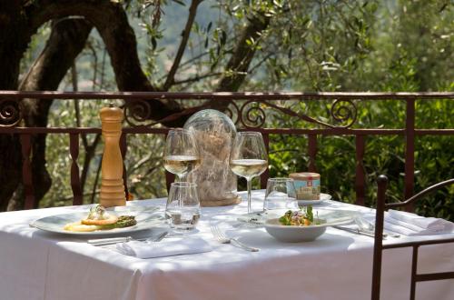 a table with wine glasses and a plate of food at Auberge De La Madone in Peillon