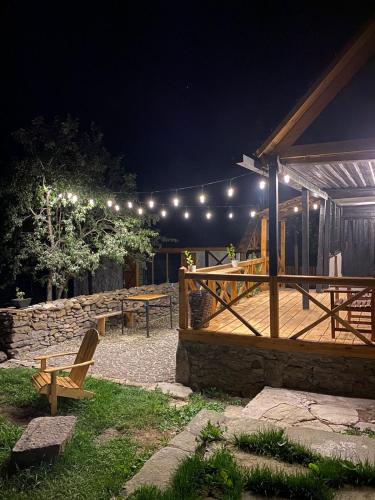 a patio at night with a picnic table and lights at Hnameni Bovadzor Lodge in Maksim Gorʼkiy