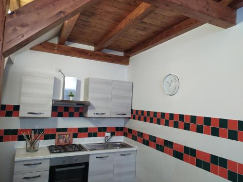 eine Küche mit roten und schwarzen Fliesen an der Wand in der Unterkunft La casa di Ornella in Avola