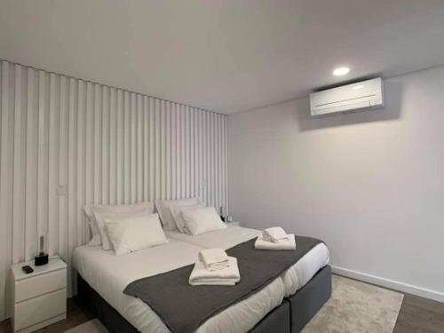 1 dormitorio con 1 cama con 2 toallas en PALHOTAS GUEST HOUSE - Apartamento Palhotas, en Braga