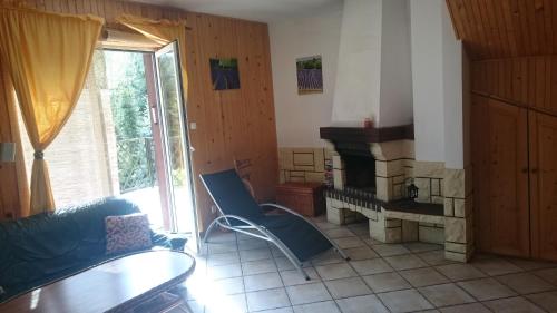 a living room with a chair and a fireplace at WILIMY Dom nad jeziorem Dadaj in Wilimy