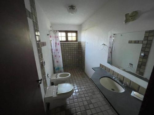 uma casa de banho com 2 lavatórios, um WC e um espelho. em Chácara linda em condomínio rural - Sousas em Campinas