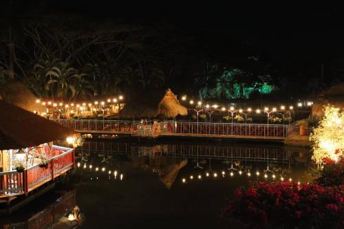 a night view of a resort with lights on the water at Hotel Campestre San Joaquin in Garzón