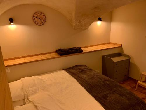 a bedroom with a bed and a clock on the wall at le Studio in Vénosc