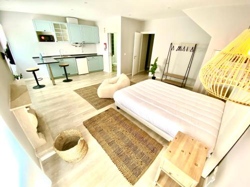 a bedroom with a large bed and a kitchen at Casa do Sol in Aveiro