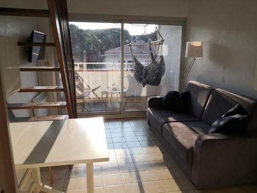 salon z kanapą i stołem w obiekcie Duplex Hyères Port w Hyères