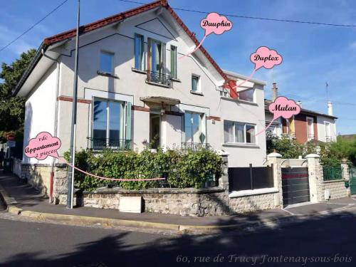 a white house with pink hello kitty signs on it at Chalet de Paris in Fontenay-sous-Bois