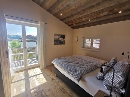 Un dormitorio con una cama y una ventana grande. en Kräuterhof Chalets, en Missen-Wilhams