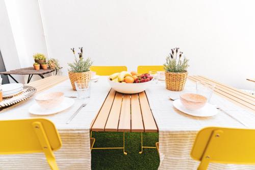a dining room table with a bowl of fruit on it at Bo&Co Apartments in Sitges