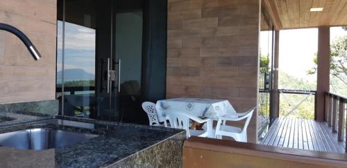 a kitchen with a table and chairs on a balcony at Marques Home in Porto Belo