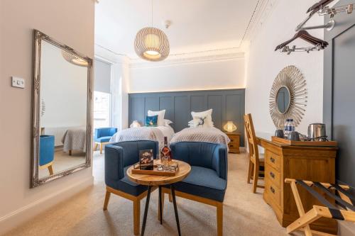 a bedroom with a bed and a table and a mirror at Annandale Guest House in St Andrews