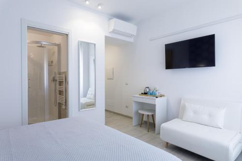 ein weißes Schlafzimmer mit einem weißen Bett und einem weißen Sofa in der Unterkunft Vista Mare Guest House in Civitanova Marche