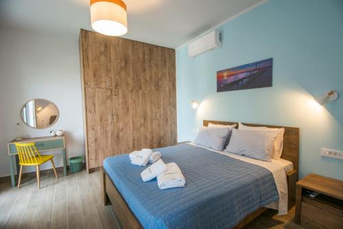 - une chambre avec un lit et des serviettes dans l'établissement Thèros garden, à Istron