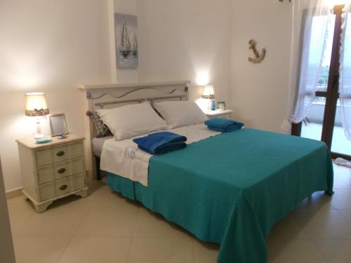 Un dormitorio con una cama con almohadas azules. en L'Ancora suite, en Orosei