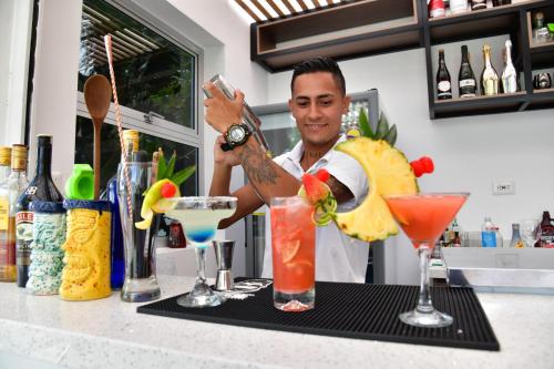 a man standing behind a bar making a drink at Alpha Hotel Boutique in Necoclí