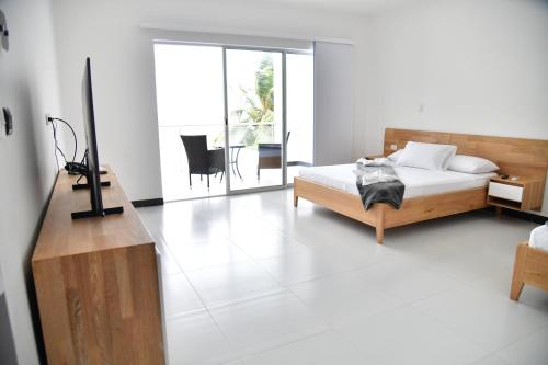 a bedroom with a bed and a dresser and a table at Alpha Hotel Boutique in Necoclí