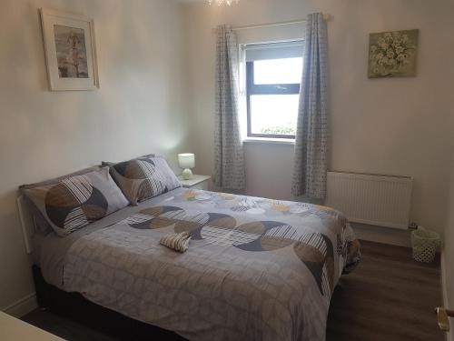 - une chambre avec un grand lit et une fenêtre dans l'établissement Sea breeze Cottage, à Dungloe