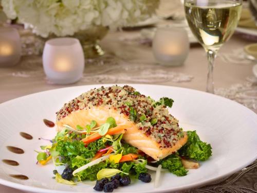 a plate of food with fish and broccoli on a table at The Royal Sonesta Harbor Court Baltimore in Baltimore