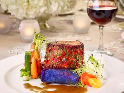 a white plate with a piece of meat and vegetables at The Royal Sonesta Harbor Court Baltimore in Baltimore