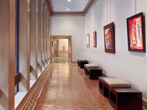 a hallway with benches and paintings on the walls at The Royal Sonesta Harbor Court Baltimore in Baltimore